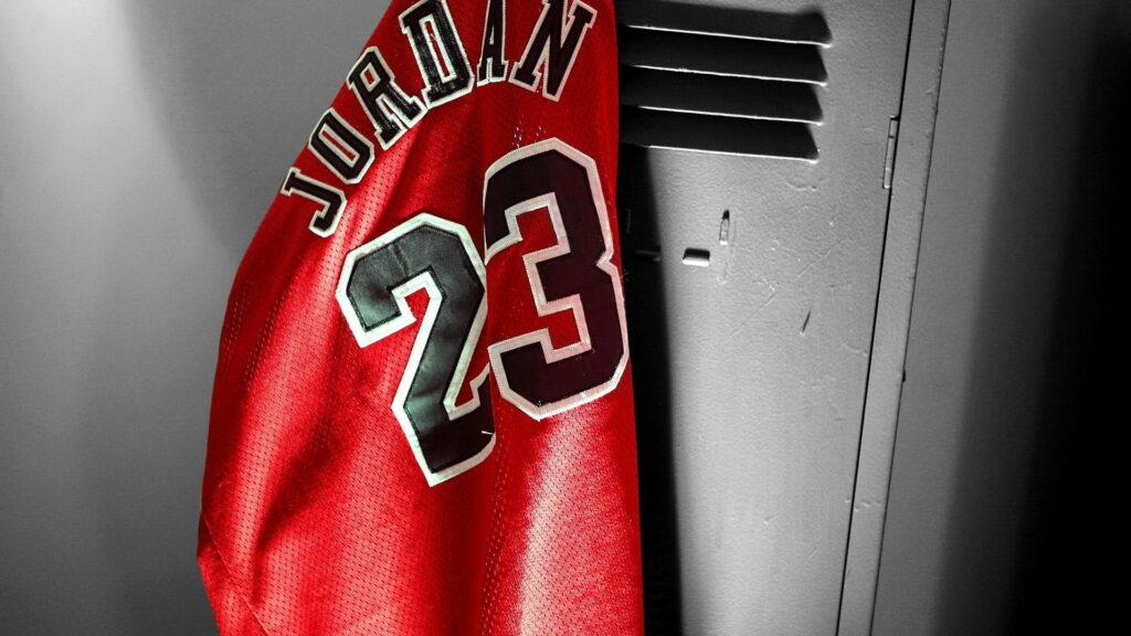 Rise Above the Competition: A Stunning HD Wallpaper featuring Red Jordan 23 NBA Jersey and Michael Jordan's Iconic Legacy in Basketball Sports!