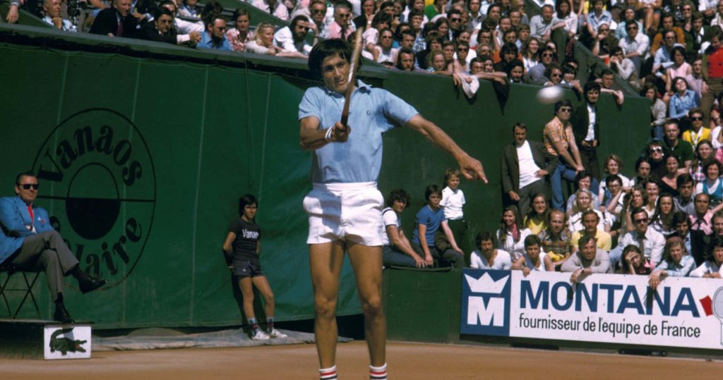 Tennis legend Ilie Năstase backhand shot Roland Garros clay courts vintage French Open wallpaper