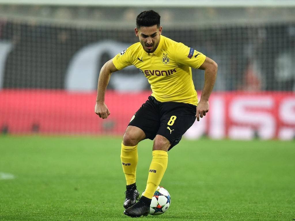 Ilkay Gundogan in Borussia Dortmund yellow black kit focused intense football action wallpaper