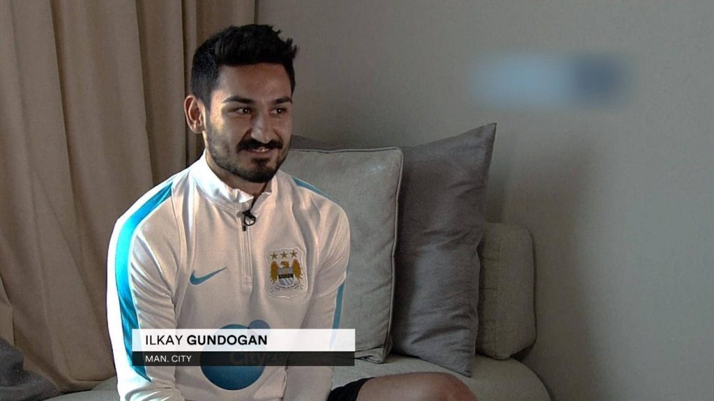Footballer İlkay Gündoğan in white Manchester City jacket during professional interview background Wallpaper