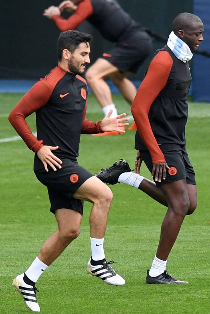 İlkay Gündoğan and Benjamin Mendy intense Manchester City training session on green grass pitch Wallpaper