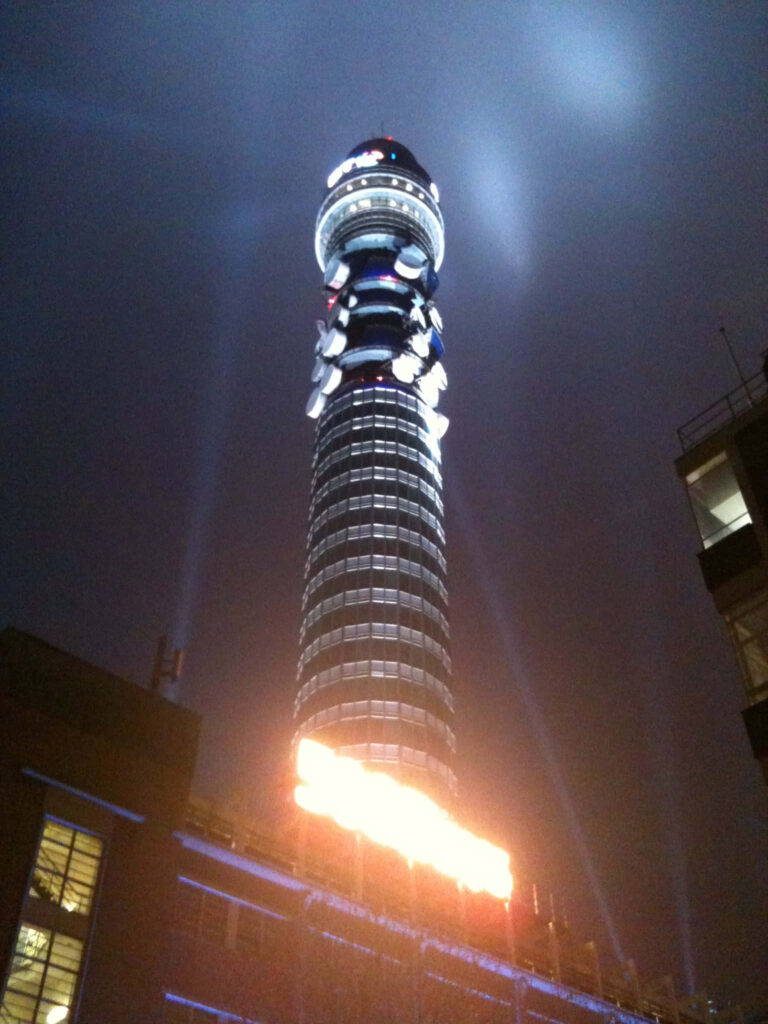Illuminated BT Tower at night vibrant cylindrical structure against deep blue sky wallpaper background