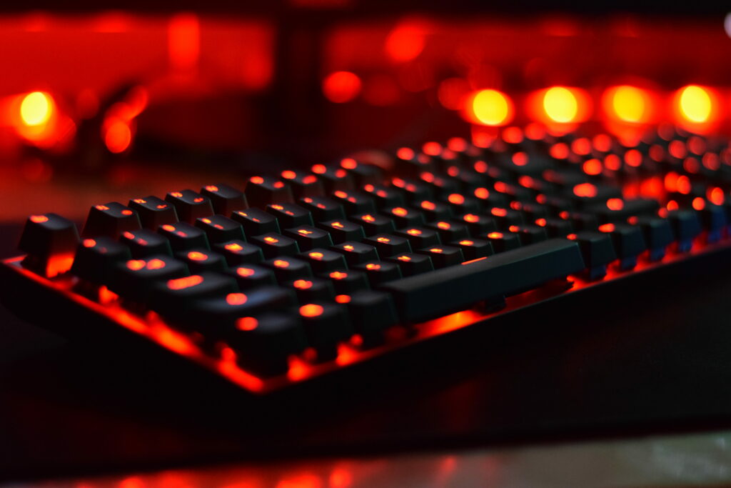 Moody high-contrast mechanical keyboard wallpaper with red backlight and cinematic bokeh background