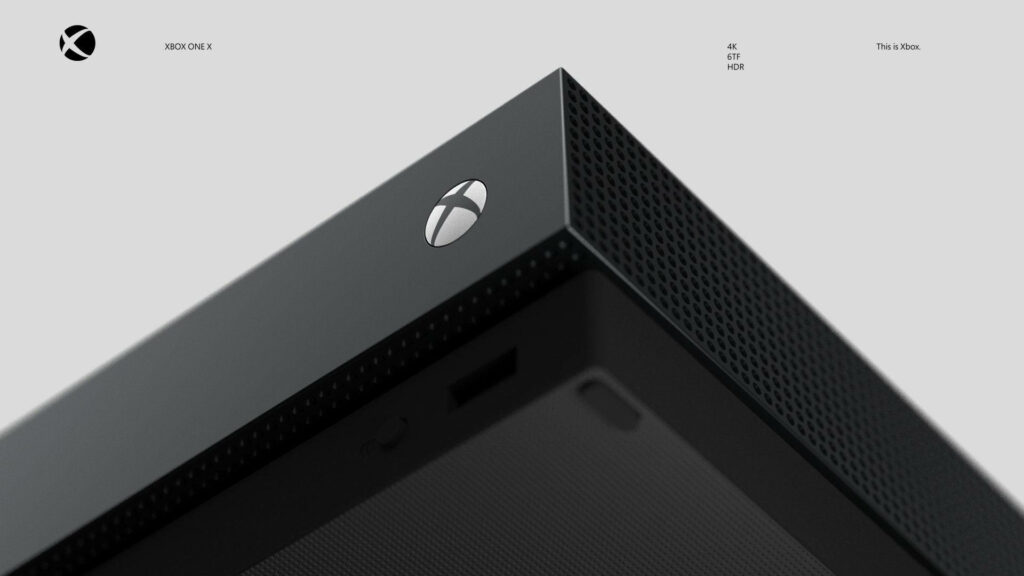 Xbox One X: Magnifying Microsoft's Iconic Logo on a Sleek Console's Edge over a Clean Canvas Wallpaper