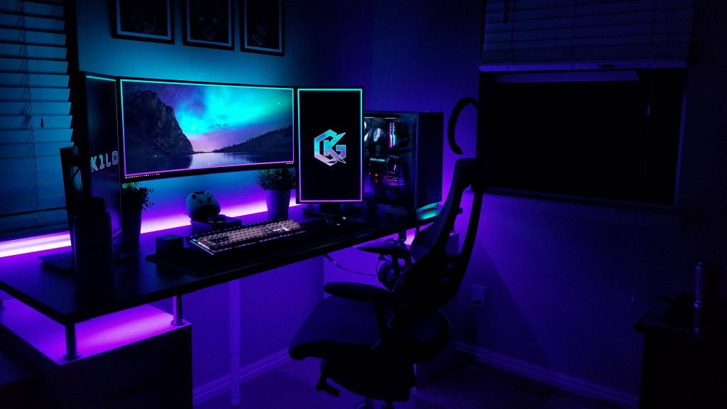 Immersive 4k dual-monitor PC gaming setup with purple blue RGB lights and aurora wallpaper