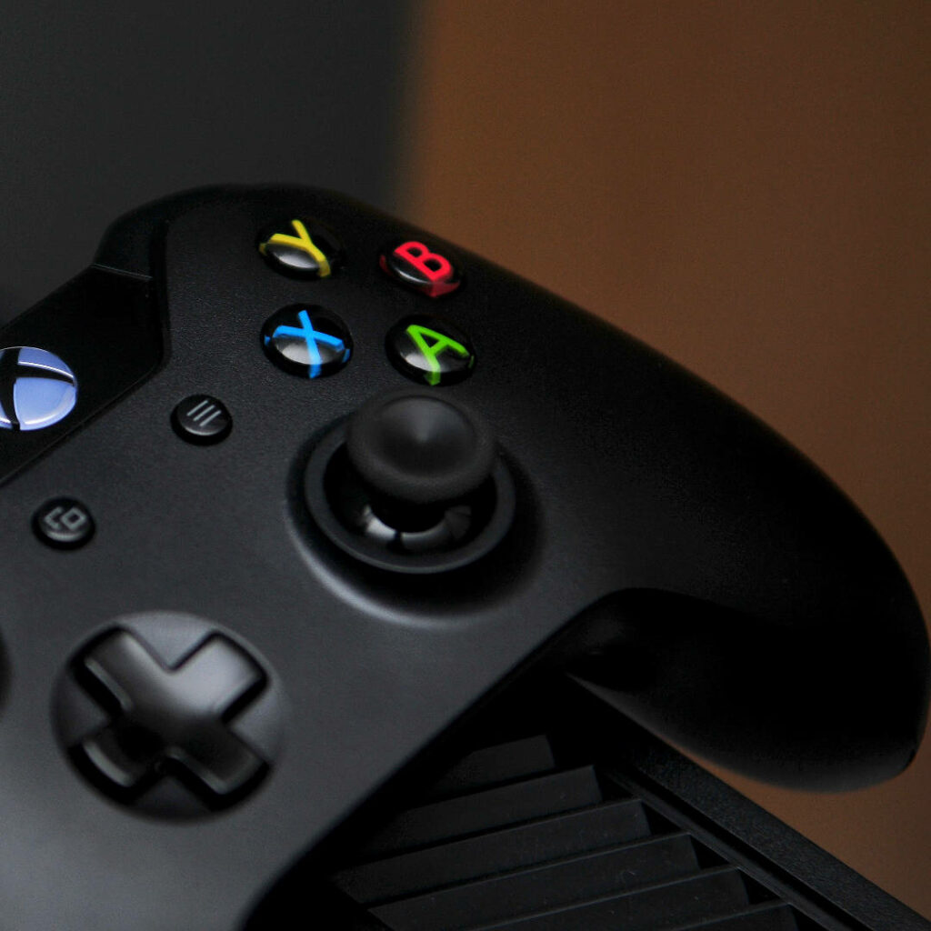 Close-Up of Sleek Black Xbox Game Controller against an Abstract Blur Wallpaper