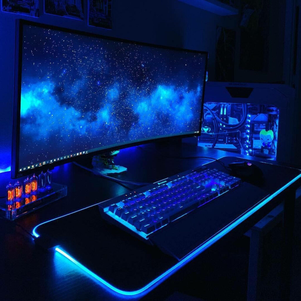 Immersive Gaming Haven: Neon Blue Accents Illuminate a Minimalist Gaming Setup in a Mysterious Dark Space Wallpaper