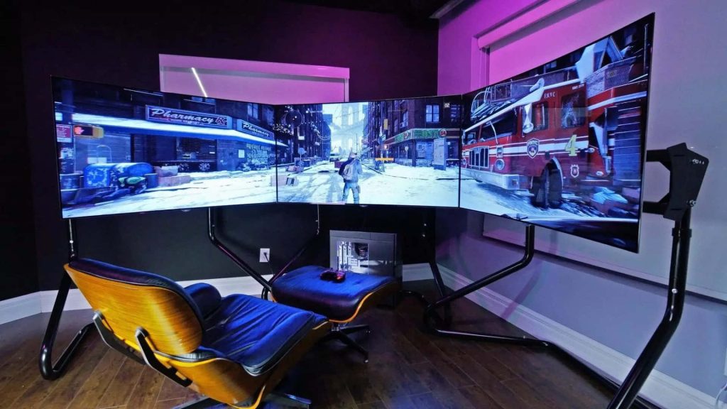Triple monitor gaming setup with Tom Clancys The Division cozy room purple ambient lighting hardwood floors Wallpaper