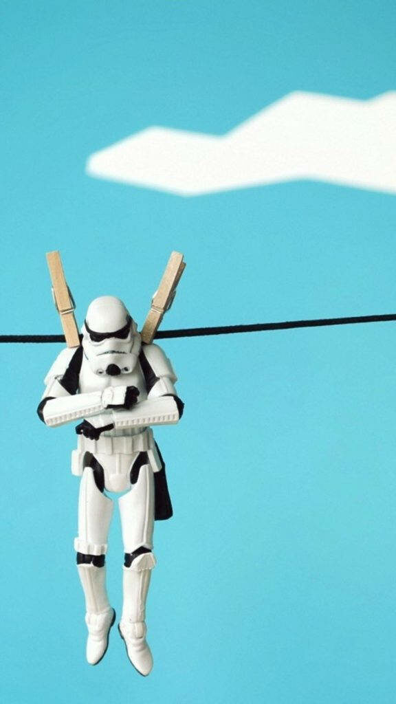 Stormtrooper Drying Out: Hilarious Star Wars iPhone Wallpaper featuring Trooper on a Clothesline Under a Blue Sky with a Lonesome Cloud