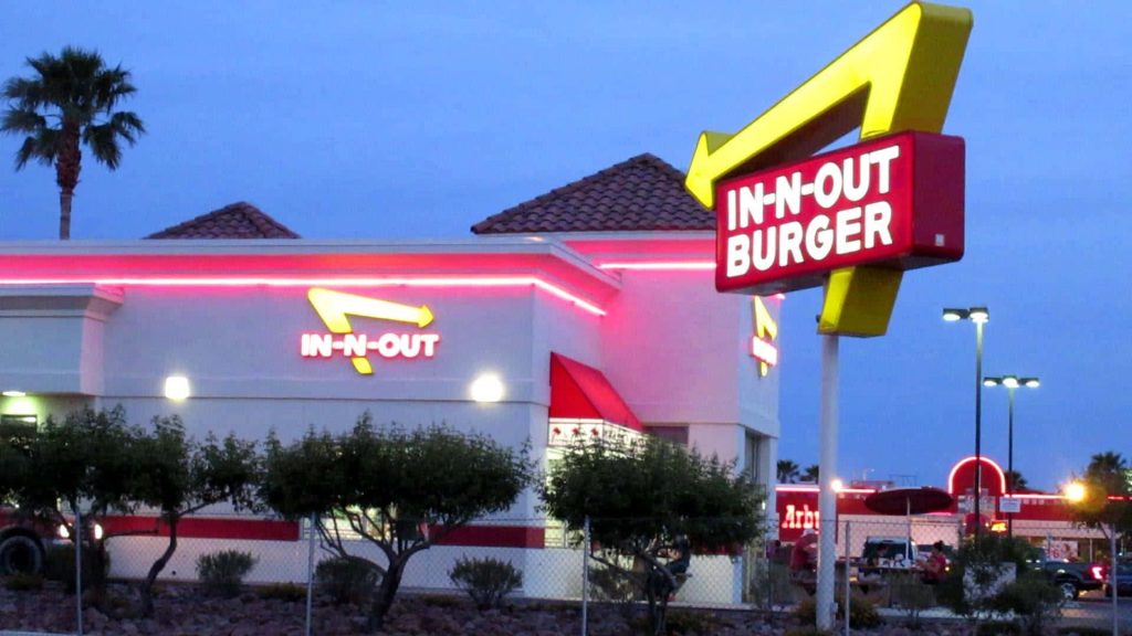 In-N-Out Burger at dusk with yellow arrow sign red accents and blue twilight sky wallpaper