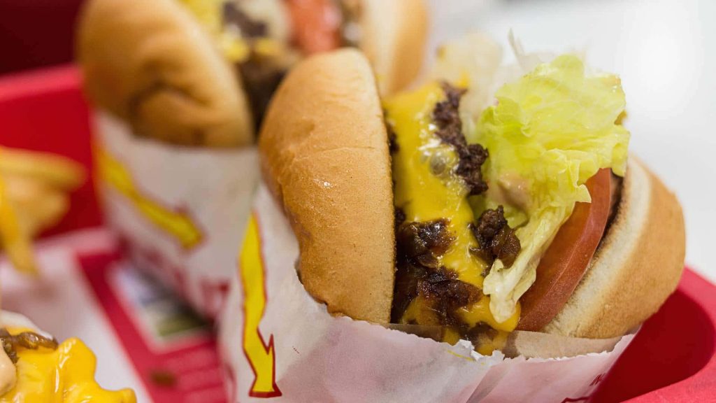 Close-up of In-N-Out Burger cheeseburger with fresh lettuce tomato melted cheese on red tray Wallpaper