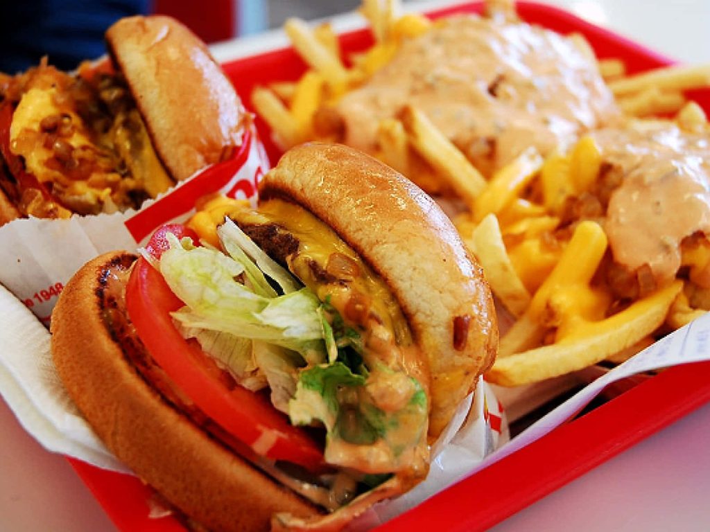 Close-up of In-N-Out cheeseburger with fresh lettuce tomato and Animal Style cheese fries on tray Wallpaper