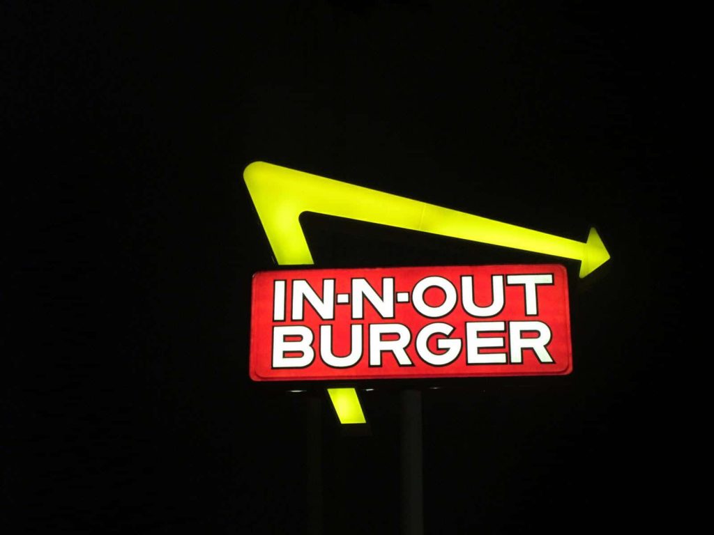 In-N-Out Burger logo glowing bright on black background high contrast fast food wallpaper