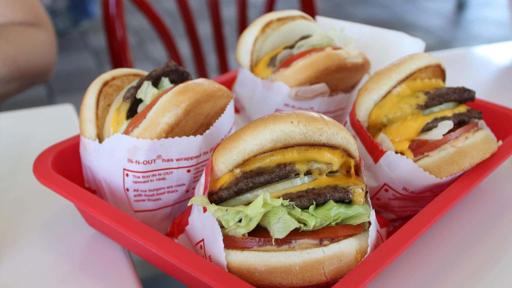 In-N-Out Burger wallpaper with four classic cheeseburgers on red tray fresh and appetizing