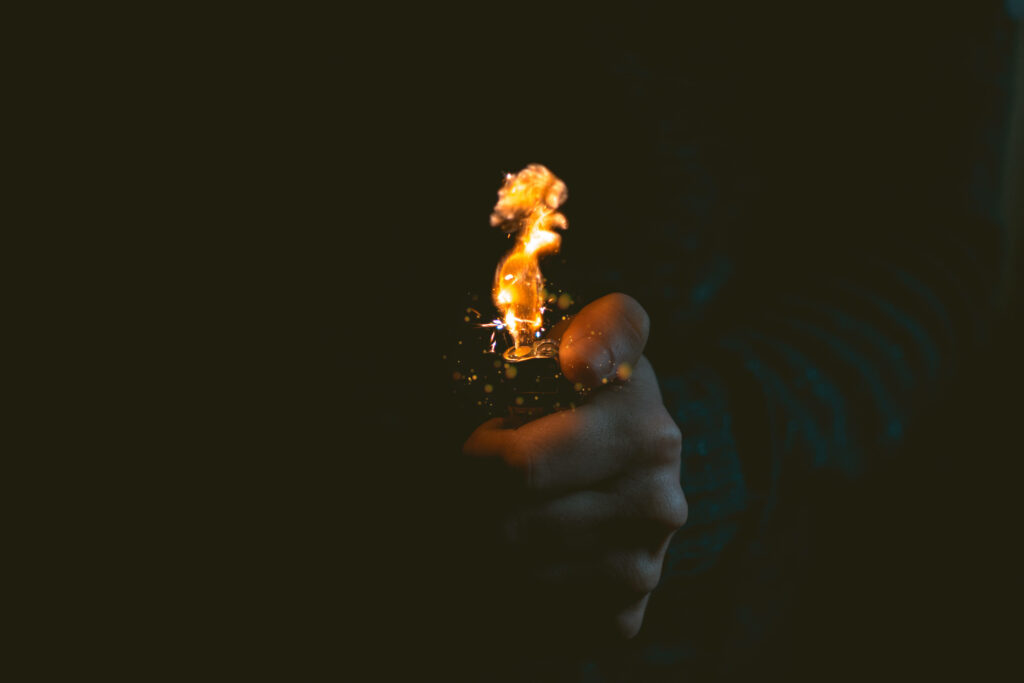 Inferno Illuminated: Hand Engulfed in Flames Against Sinister Backdrop Wallpaper