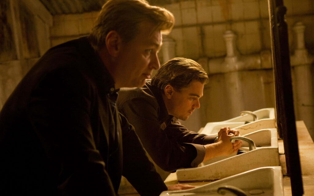 Inception wallpaper showing two main characters reflecting at sinks in a dimly lit intense scene
