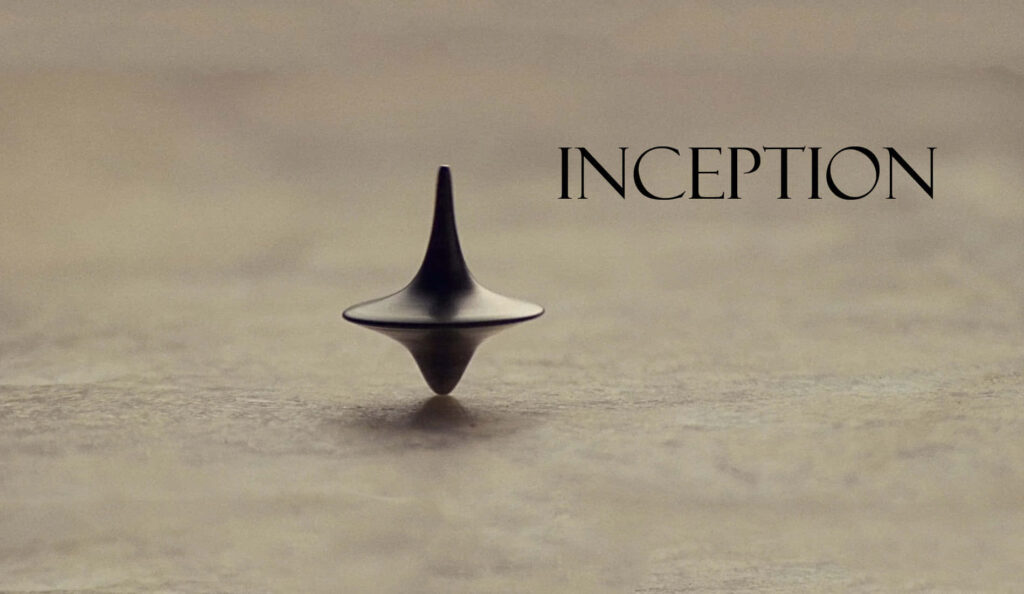 Close-up of Inception spinning top with minimalist background and movie title elegant wallpaper