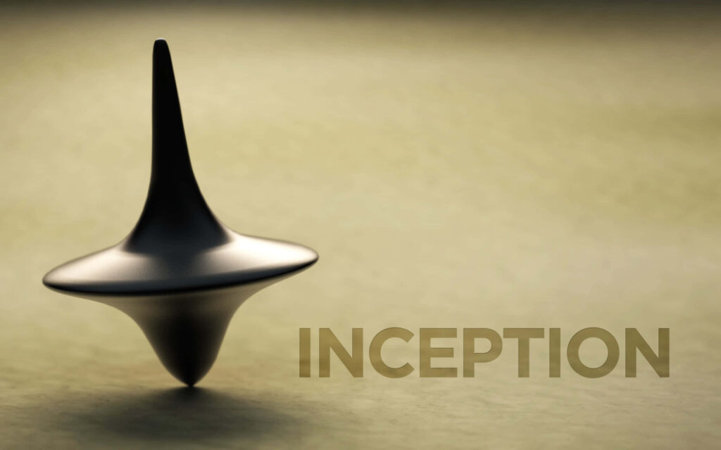 Inception spinning top still image with blurred background and elegant movie title wallpaper