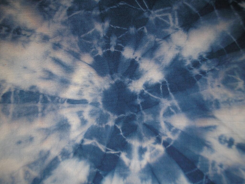 Tie-dye wallpaper with deep indigo and soft white burst pattern in vintage artistic style background