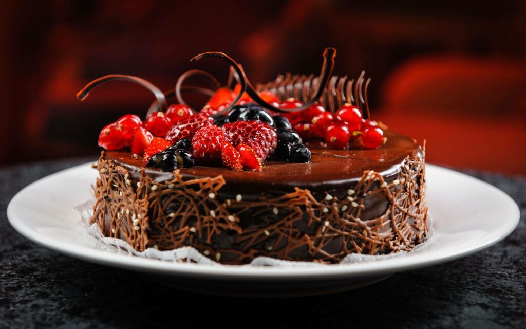 Birthday Bliss: Tempting Chocolate Cake Adorned With Luscious Fruits Wallpaper