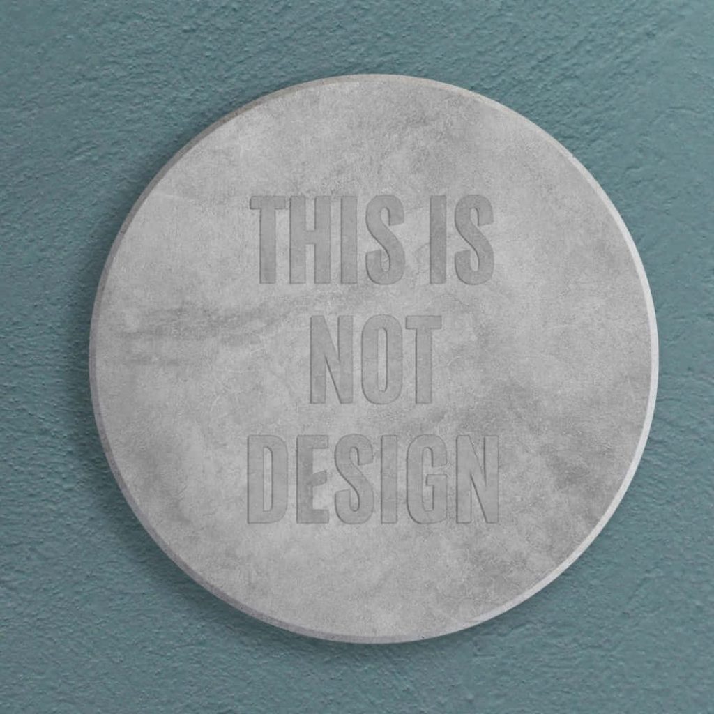 Industrial concrete coin wallpaper with teal textured wall and bold THIS IS NOT DESIGN text