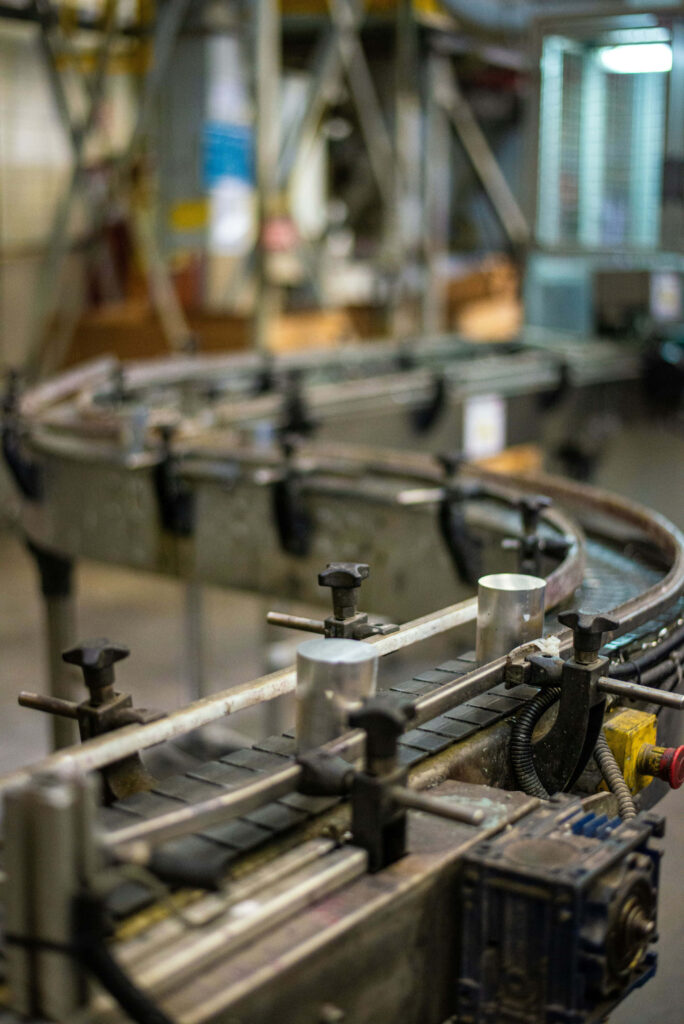 Close-up of industrial conveyor system with metallic rails and machinery in factory setting Wallpaper