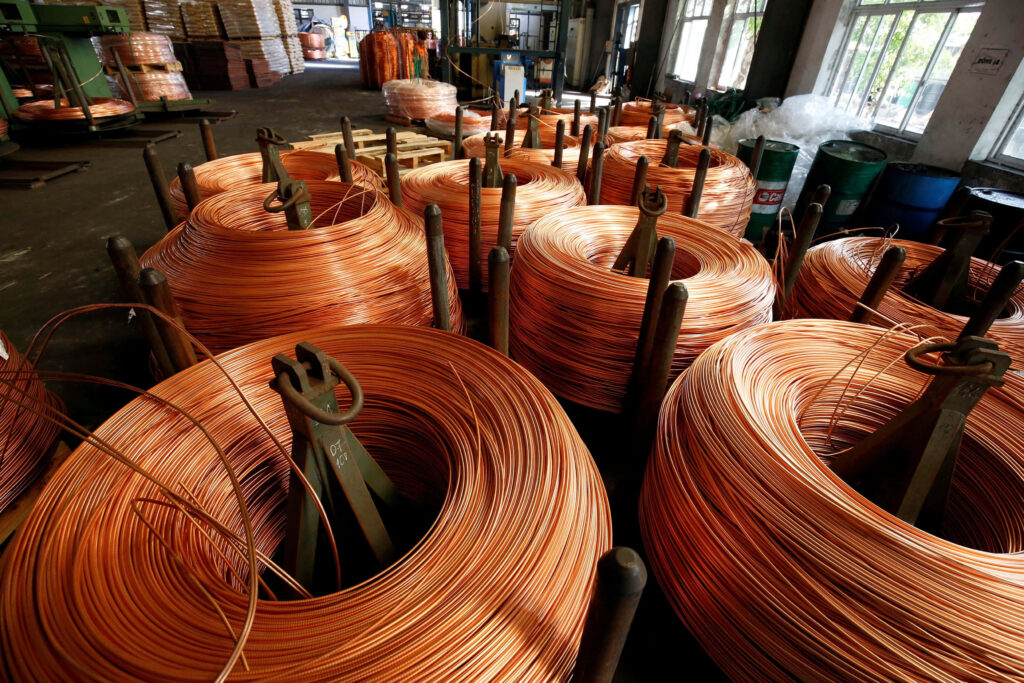 Large shiny copper wire coils in industrial factory with warm metallic tones and organized layout Wallpaper