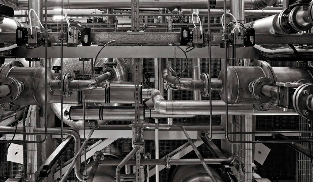 Industrial factory wallpaper with detailed pipes valves and metallic structures in monochrome