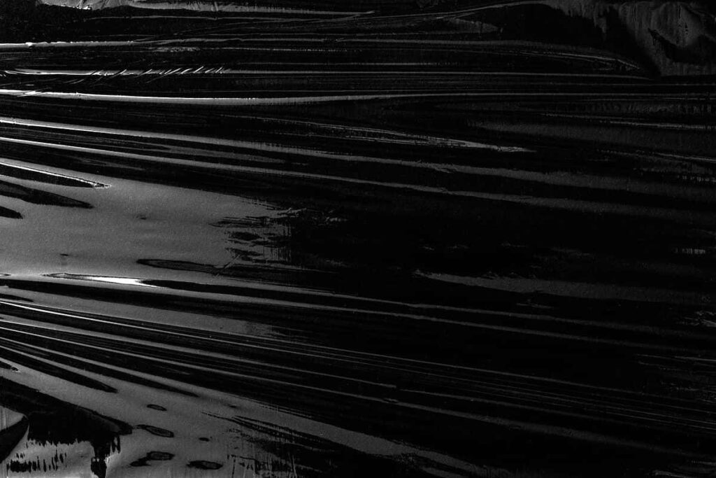 Dark and Sleek: Exploring the Beauty of a Black Plastic Background Wallpaper