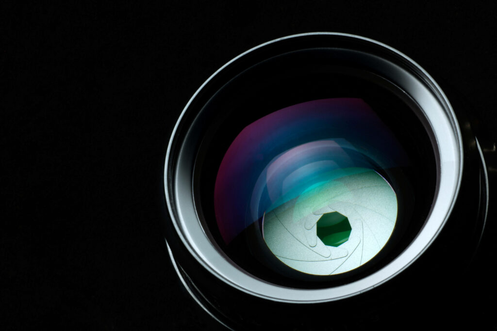 Capturing Shadows: A Sleek Camera Lens against a Deep Ebony Backdrop Wallpaper