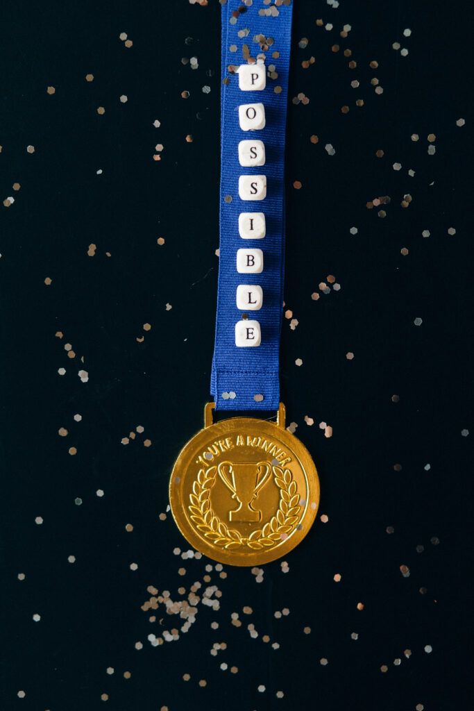 Gold Medal 'Possible' iPhone Wallpaper with Confetti & Blue Ribbon