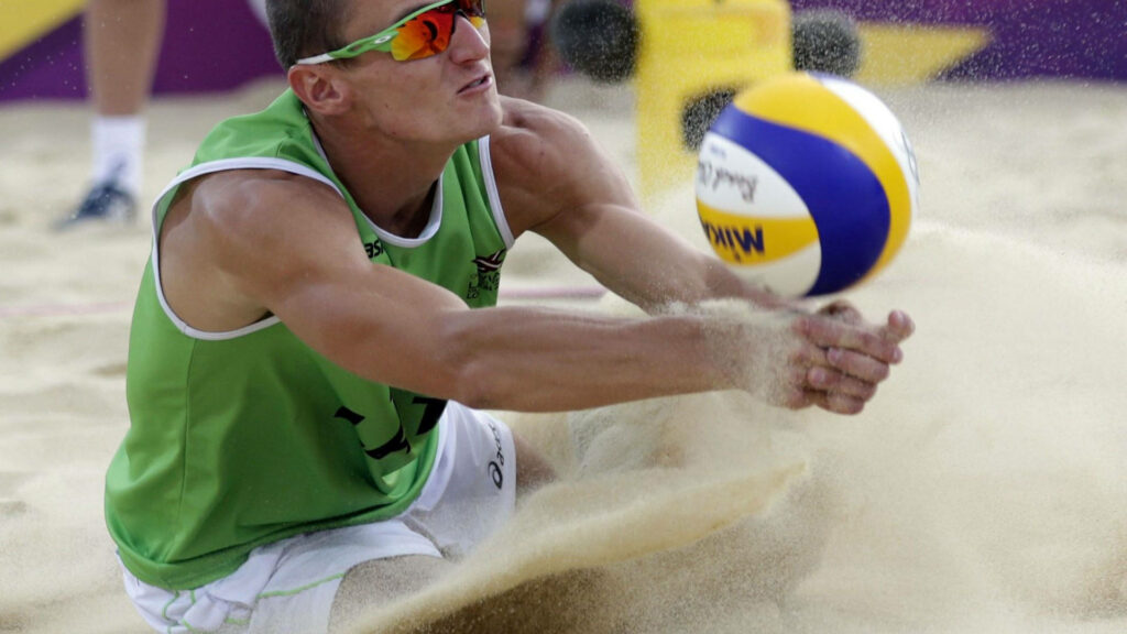 Dynamic Beach Volleyball Action: Player Digs Ball with Mikasa Gear Wallpaper