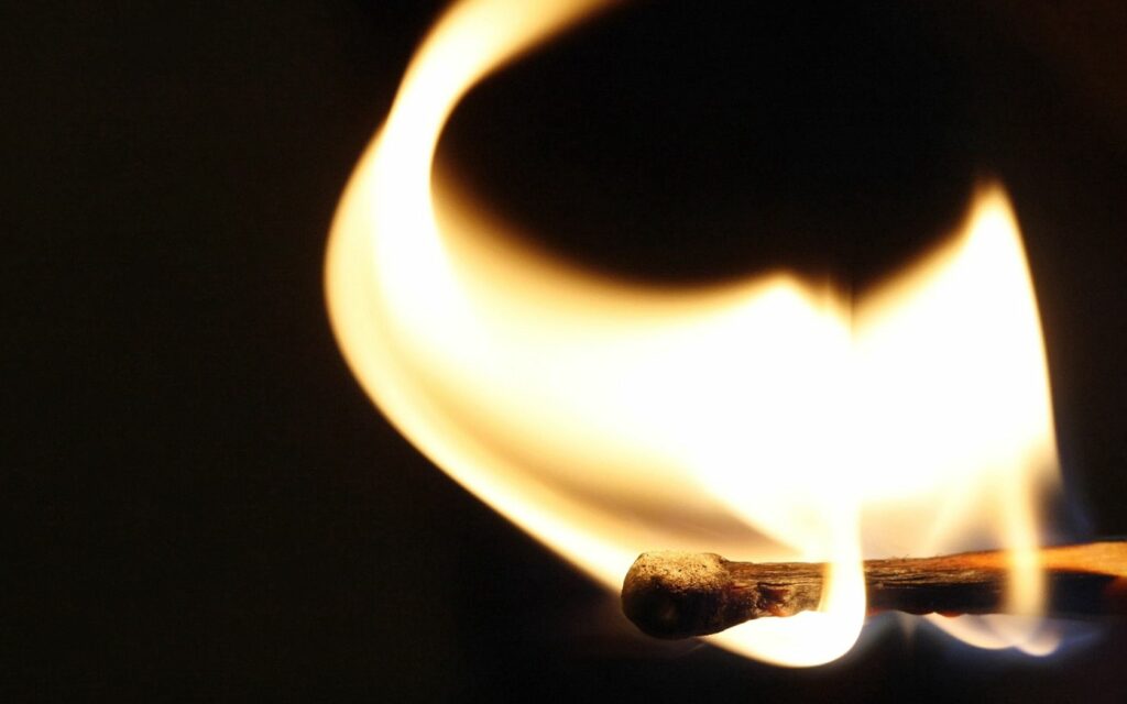 Fiery Matchstick Wallpaper: Vibrant Flames on Dark Background