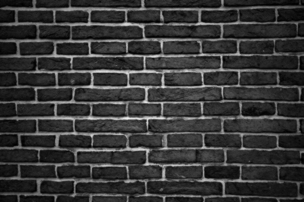 Intense Texture: A Close-up of Dark Bricks Wallpaper Set Against a Majestic Dark Wall