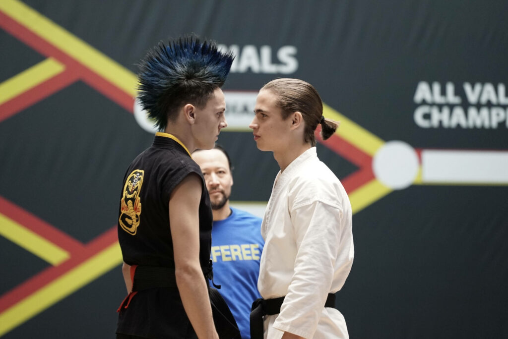 Cobra Kai Wallpaper: Robby vs. Hawk Intense Face-Off Background