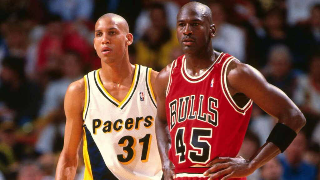 Breathtaking Rivalry: Reggie Miller and Michael Jordan Lock Eyes in Legendary NBA Battle Wallpaper
