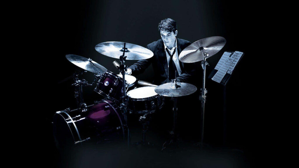 Intense Drummer Under Spotlight - Captivating Wallpaper Background