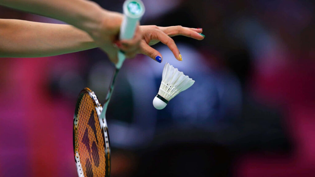 Focused Fury: Racket and Gaze Meet in Badminton Battle Wallpaper