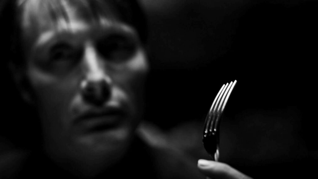 Dark Hannibal Wallpaper: Intense Fork Scene & Mysterious Background