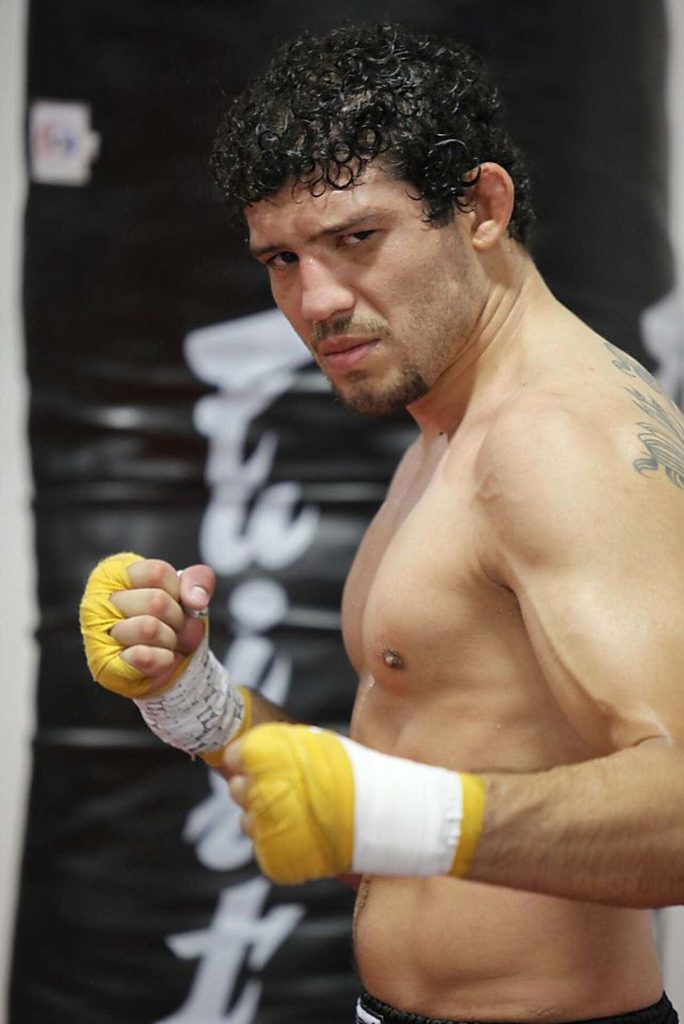 MMA champion Gilbert Melendez training bare-chested with yellow wraps in gym wallpaper