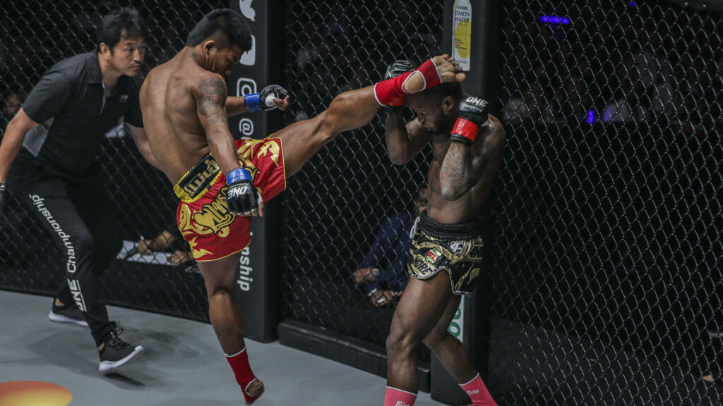 Intense Muay Thai Match Wallpaper: High Kick Action Background