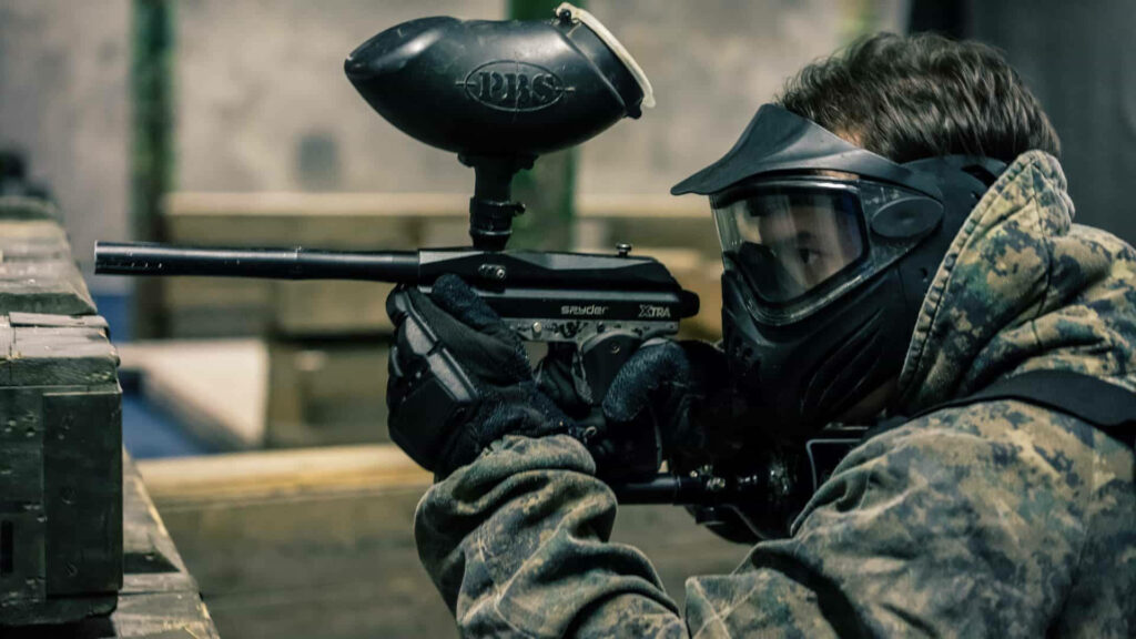 Intense Paintball Action: Player in Woodland Camouflage - Wallpaper