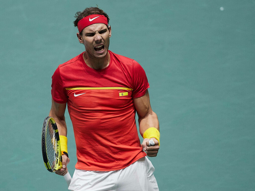 Intense Rafael Nadal Tennis Moment: Vibrant Red & Yellow Wallpaper