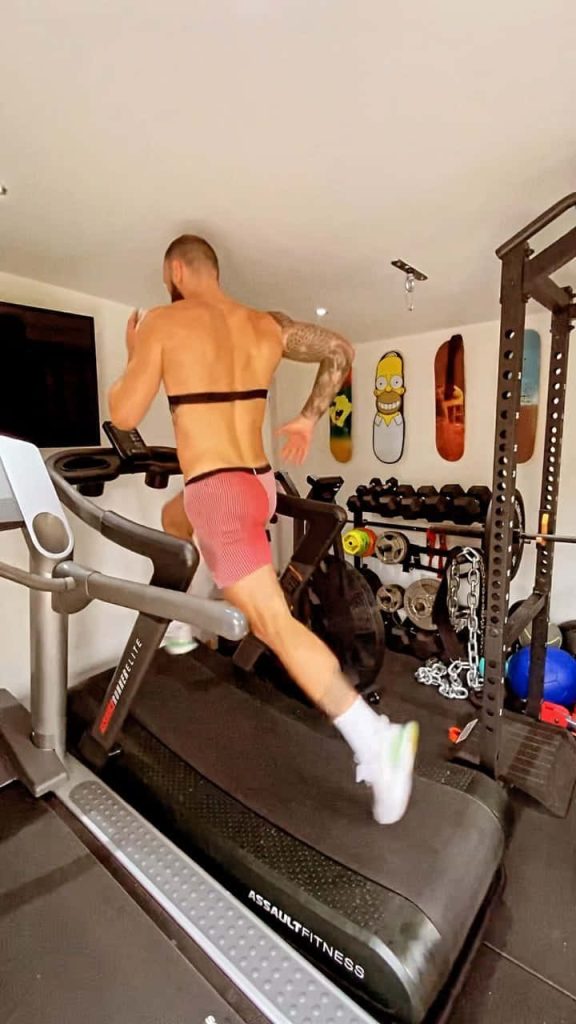 UFC fighter Paul Craig training intensely on AssaultRunner Elite treadmill in home gym Wallpaper