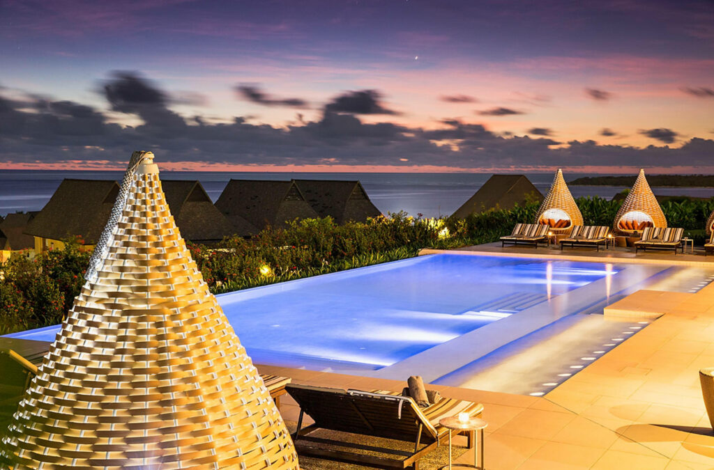 Evening ocean sunset at Intercontinental Fiji with infinity pool modern lounge chairs woven cabanas Wallpaper