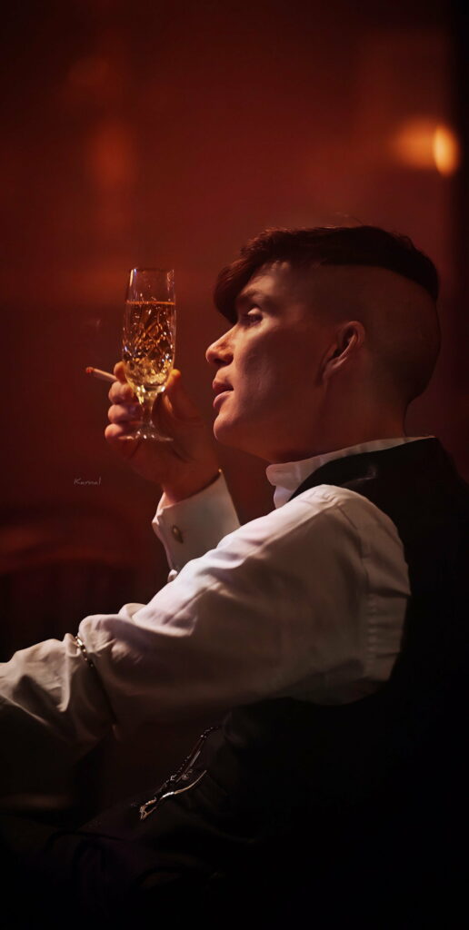Gritty Elegance: Thomas Shelby From Peaky Blinders Raises a Toast on a Stylish HD Phone Wallpaper