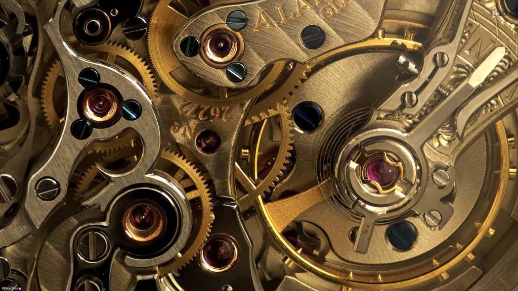Macro close-up of A Lange Sohne watch movement with brass gears polished bridges and ruby bearings Wallpaper