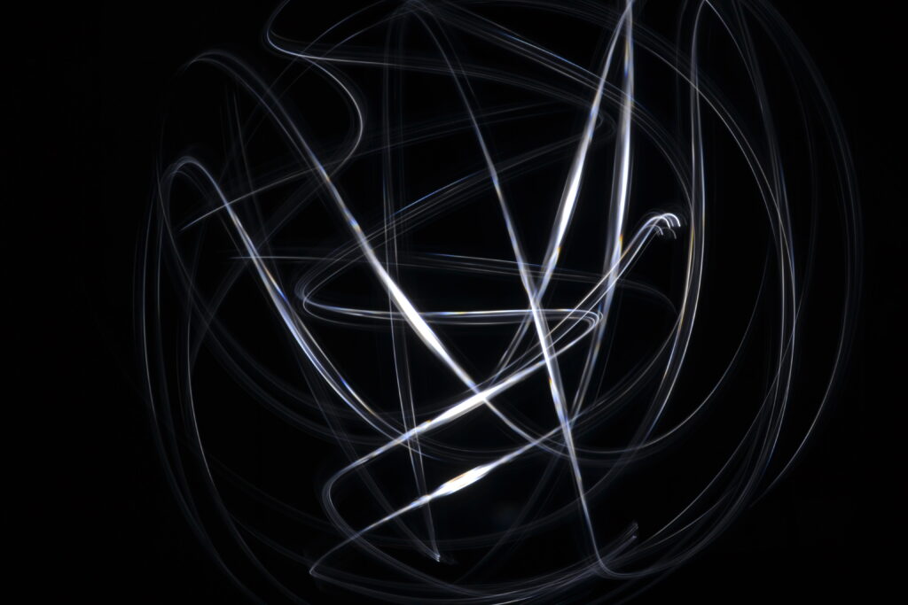 Intricate Black and White Wallpaper: Light Trails on Dark Background