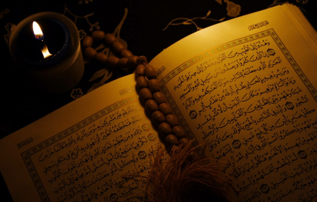 Intricate Border Design Illuminating an Old Quran with Stunning Script Wallpaper