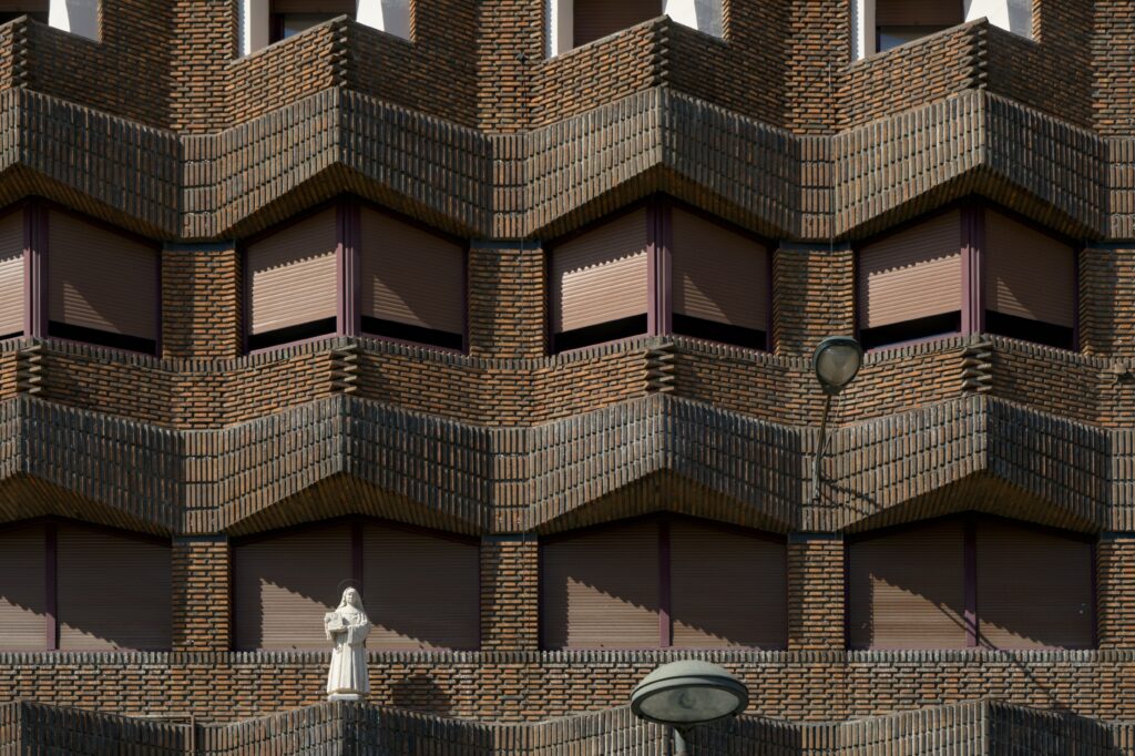 Intricate Brick Building Wallpaper: Symmetrical Artistic Design